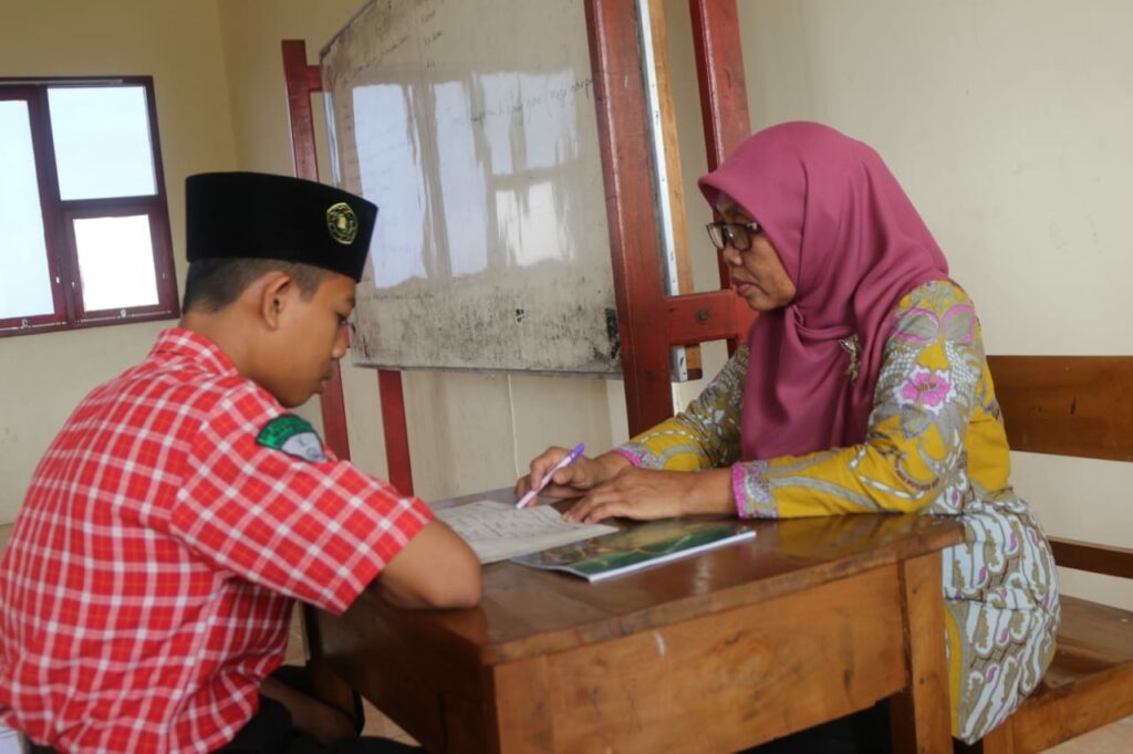 Seorang siswa SMK Assa'adah belajar membaca Alquran kepada guru yang sudah bersyahadah, Rabu 7 September 2022. Foto: QOM.
