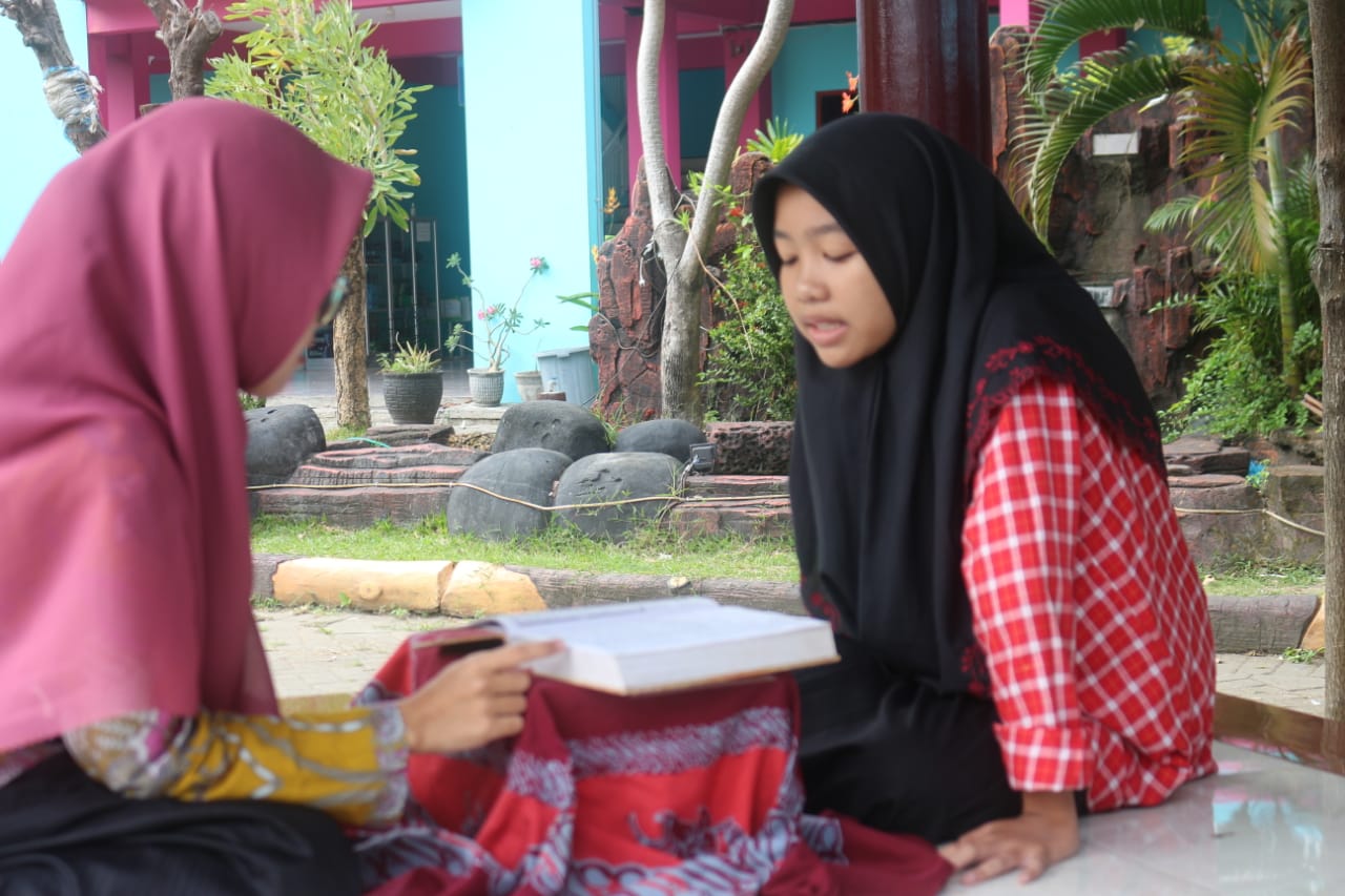 Seorang siswi SMK Assa'adah belajar membaca Alquran kepada guru yang sudah bersyahadah, Rabu 7 September 2022. Foto: QOM.